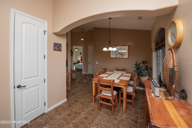 tiled dining room with lofted ceiling and a chandelier