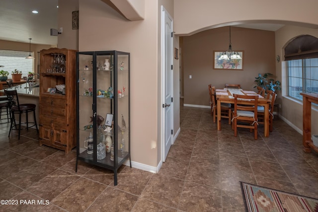 dining area with dark tile patterned floors, an inviting chandelier, and a wealth of natural light