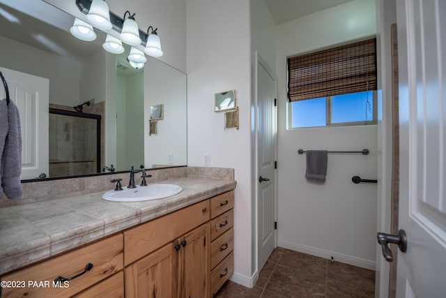 bathroom with tile patterned flooring, vanity, and a shower with door