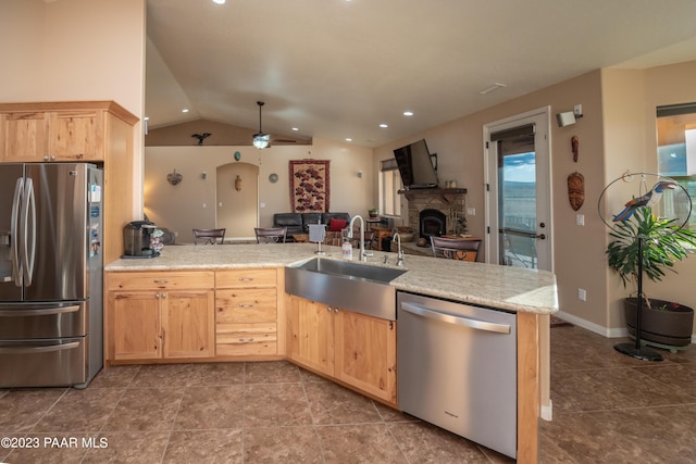 kitchen with ceiling fan, sink, light brown cabinets, vaulted ceiling, and appliances with stainless steel finishes