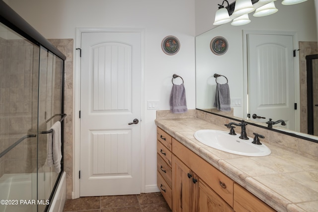 bathroom featuring tile patterned floors, vanity, and bath / shower combo with glass door