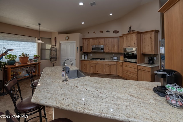 kitchen with lofted ceiling, backsplash, sink, a kitchen bar, and stainless steel appliances