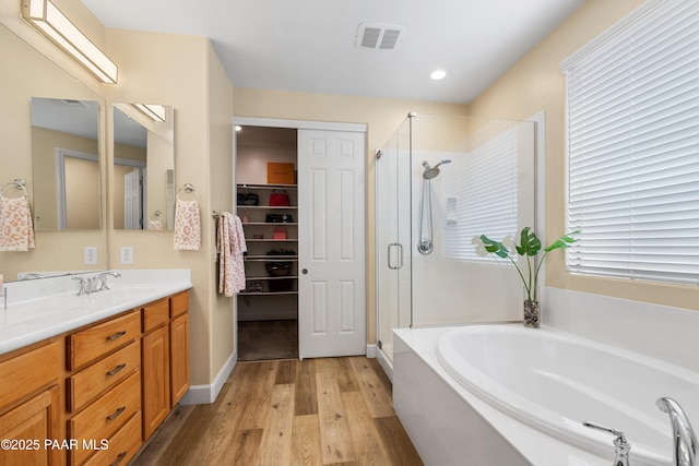 bathroom with hardwood / wood-style flooring, shower with separate bathtub, and vanity