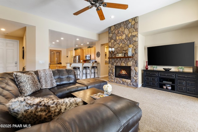 carpeted living room featuring ceiling fan and a fireplace