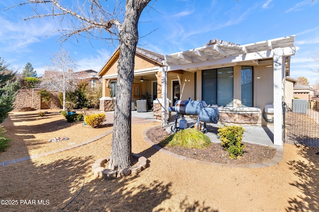 view of front of property featuring central AC, a pergola, and a patio