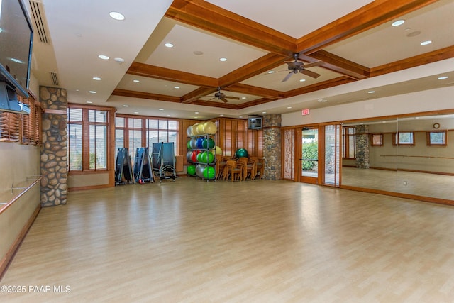 workout area with coffered ceiling and light hardwood / wood-style floors