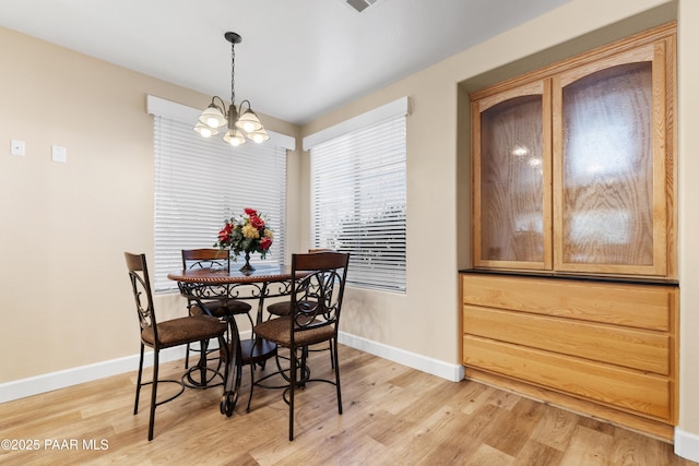 dining area featuring a chandelier and light hardwood / wood-style floors