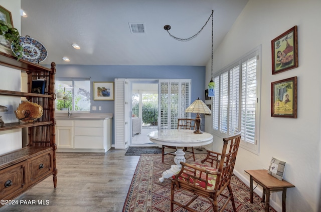 dining space featuring a wealth of natural light, light hardwood / wood-style floors, and lofted ceiling