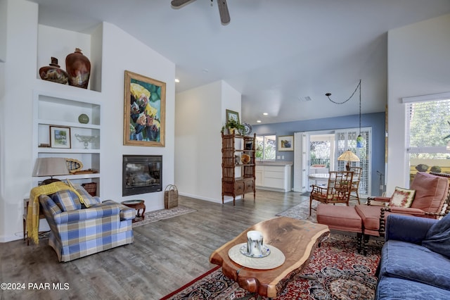 living room featuring ceiling fan, built in features, and wood-type flooring