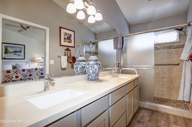 bathroom featuring hardwood / wood-style floors, vanity, lofted ceiling, ceiling fan with notable chandelier, and a tile shower