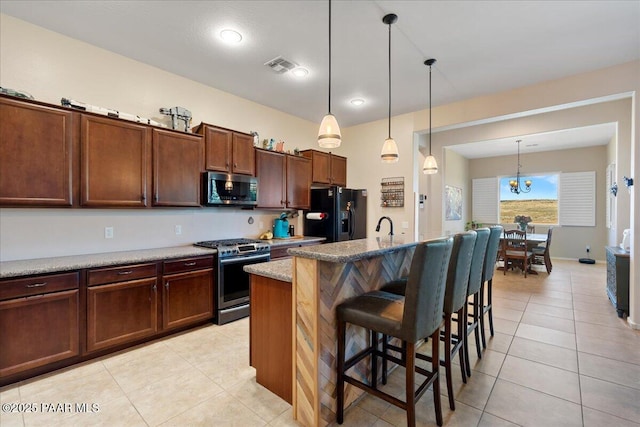 921 N Soliz St, Dewey-Humboldt, AZ 86327 - kitchen featuring appliances with stainless steel finishes, light tile patterned floors, a breakfast bar, and pendant lighting