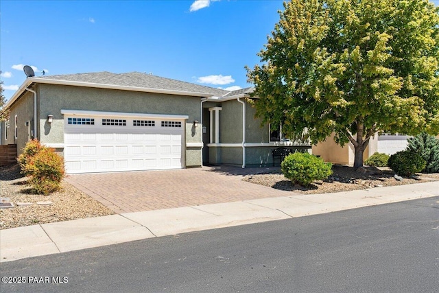 921 N Soliz St, Dewey-Humboldt, AZ 86327 - ranch-style house featuring decorative driveway, a garage, and stucco siding