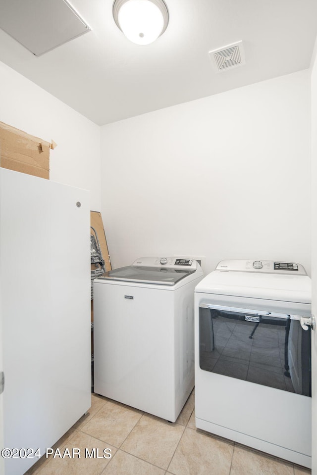 laundry room with light tile patterned floors and separate washer and dryer