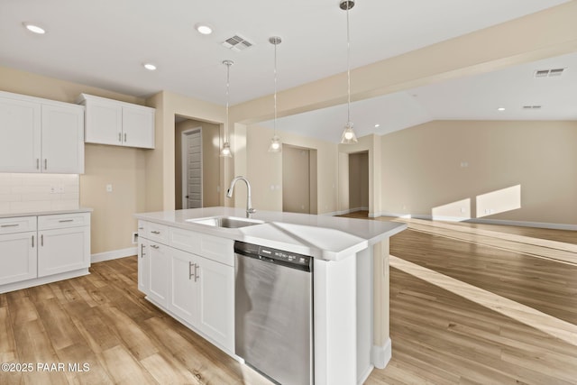 kitchen featuring white cabinetry, decorative light fixtures, stainless steel dishwasher, and a center island with sink