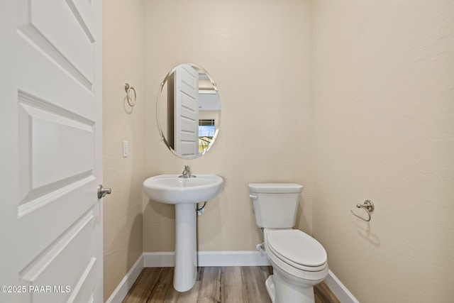 bathroom with hardwood / wood-style flooring, sink, and toilet