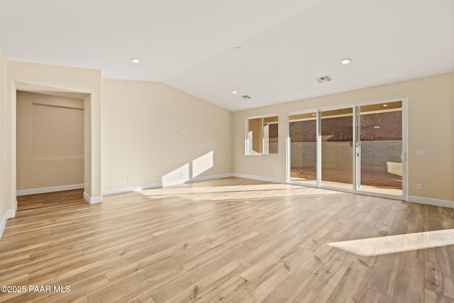 unfurnished living room with lofted ceiling and light wood-type flooring