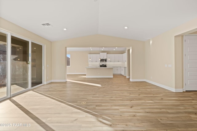 unfurnished living room with lofted ceiling and light wood-type flooring