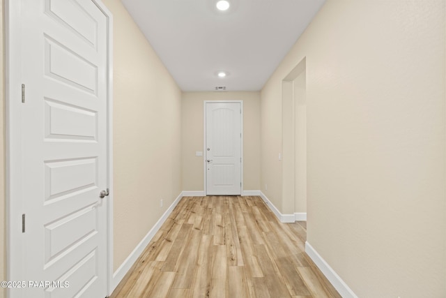 hallway with light hardwood / wood-style floors