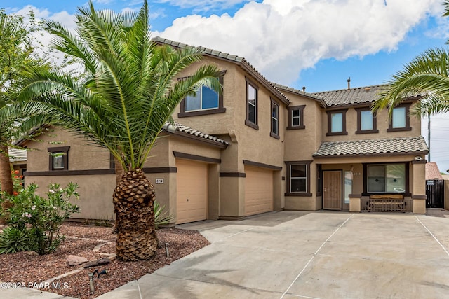 8214 S 48th Dr, Laveen, AZ 85339 - townhome / multi-family property featuring a tiled roof, an attached garage, driveway, stucco siding, and covered porch