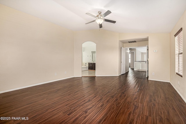 8214 S 48th Dr, Laveen, AZ 85339 - unfurnished living room with arched walkways, a ceiling fan, and dark wood-type flooring