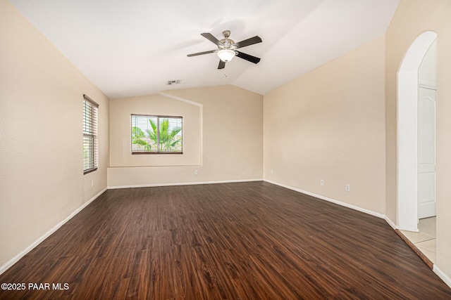 8214 S 48th Dr, Laveen, AZ 85339 - unfurnished room featuring dark wood finished floors, vaulted ceiling, ceiling fan, and arched walkways