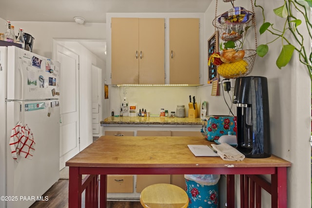 kitchen featuring white refrigerator and light stone counters