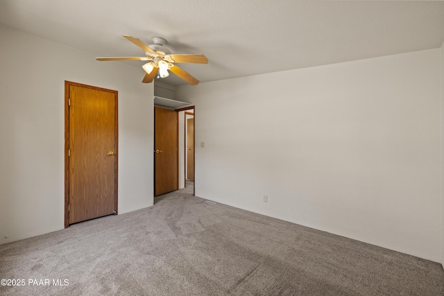 carpeted spare room featuring ceiling fan