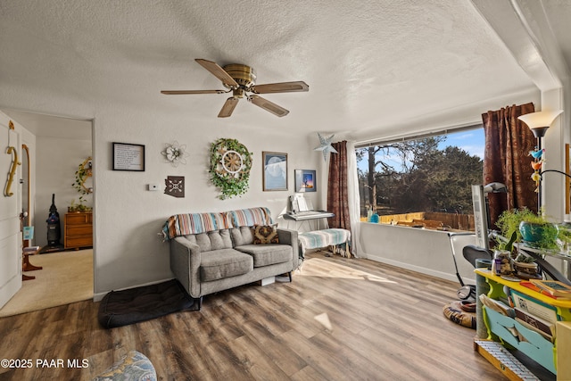 living room featuring ceiling fan, hardwood / wood-style flooring, and a textured ceiling