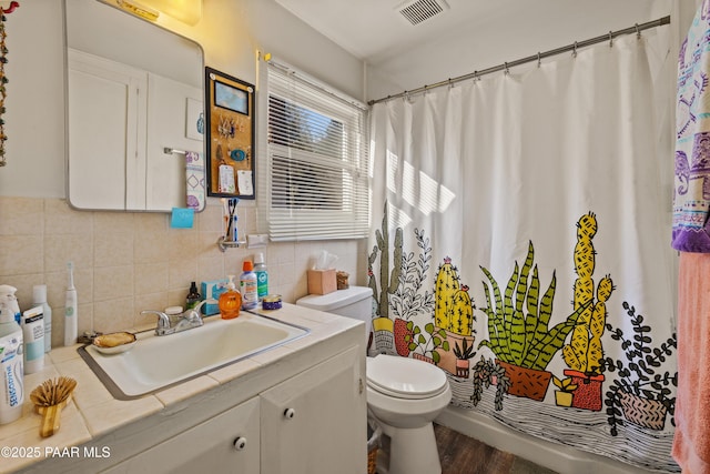 bathroom featuring vanity, decorative backsplash, toilet, and hardwood / wood-style flooring