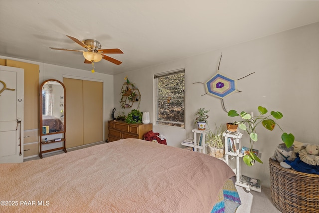 carpeted bedroom with ceiling fan and a closet