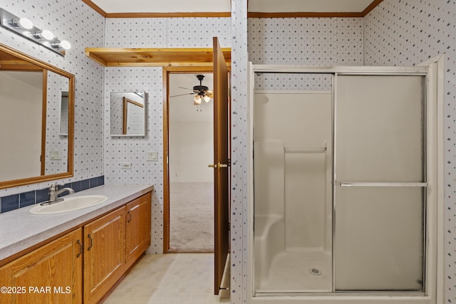 bathroom featuring an enclosed shower, vanity, and ceiling fan