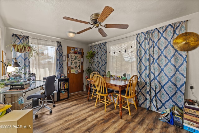 dining room featuring ceiling fan, wood-type flooring, and a textured ceiling