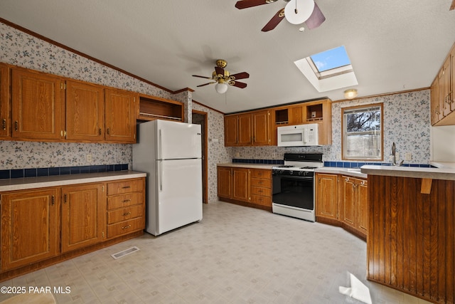 kitchen featuring sink, crown molding, vaulted ceiling, ceiling fan, and white appliances