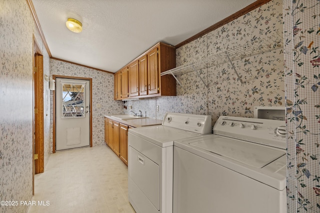 washroom with sink, cabinets, ornamental molding, washing machine and clothes dryer, and a textured ceiling