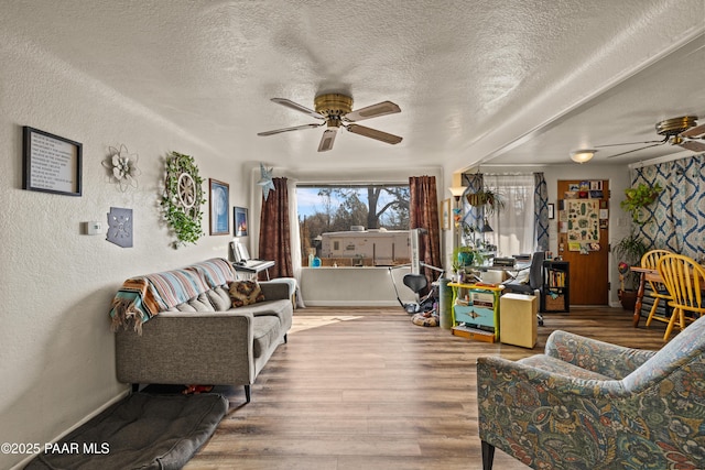 living room with hardwood / wood-style flooring, a textured ceiling, and ceiling fan