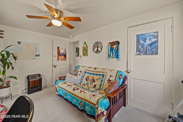 carpeted living room with heating unit and ceiling fan