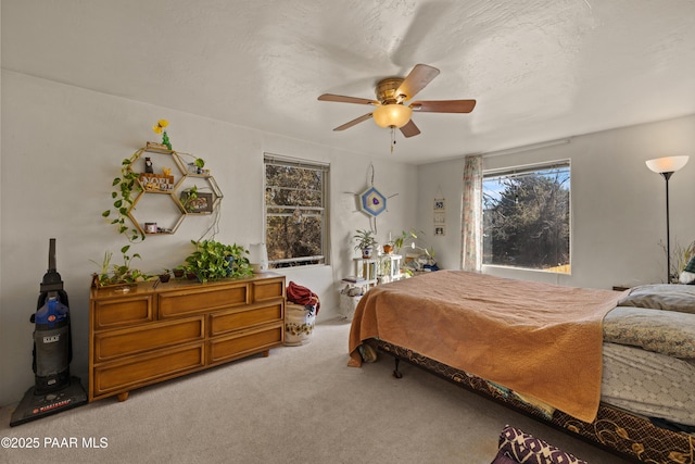 bedroom featuring ceiling fan, carpet flooring, and a textured ceiling