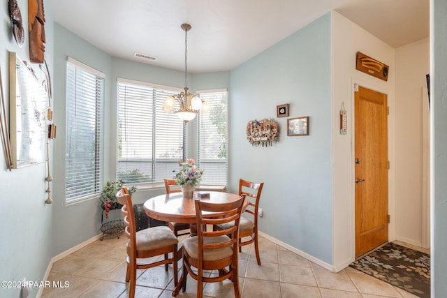 tiled dining room featuring a wealth of natural light and a chandelier