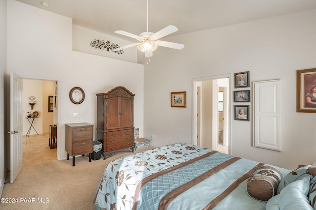 carpeted bedroom with ceiling fan and high vaulted ceiling