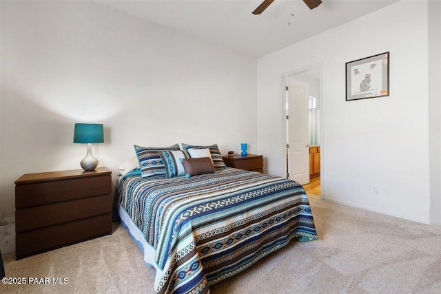 bedroom featuring light carpet, ensuite bath, and ceiling fan