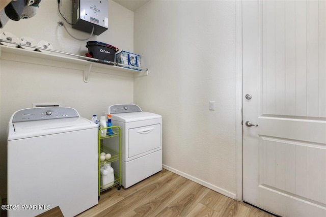 laundry area featuring light hardwood / wood-style flooring and washing machine and clothes dryer