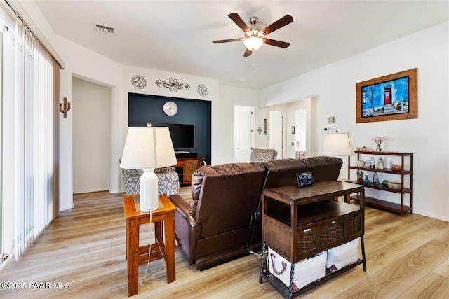 living room featuring ceiling fan and light hardwood / wood-style flooring