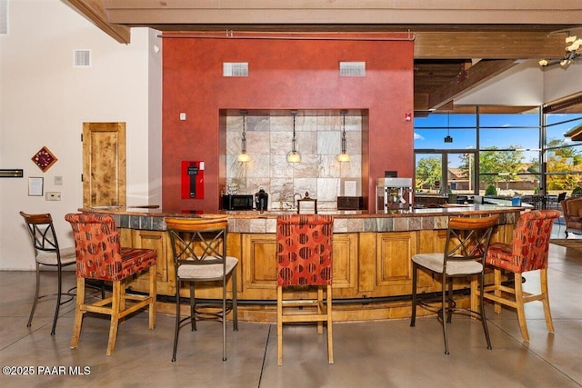 13014 E Vega St, Dewey-Humboldt, AZ 86327 - indoor wet bar featuring finished concrete floors, beamed ceiling, and a towering ceiling
