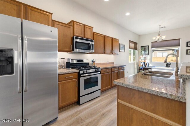13014 E Vega St, Dewey-Humboldt, AZ 86327 - kitchen with stainless steel appliances, brown cabinets, a chandelier, light wood-style flooring, and recessed lighting
