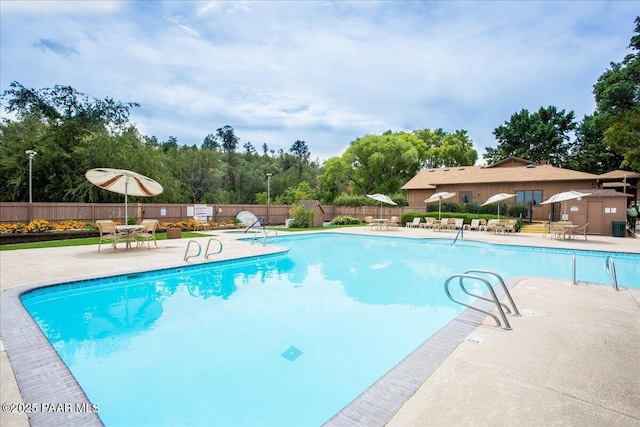 pool with a patio area and fence