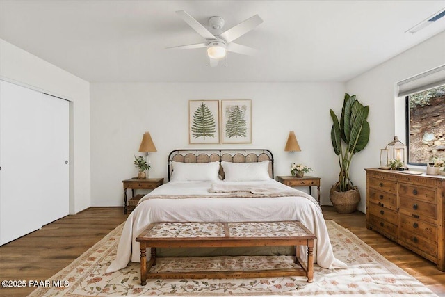 bedroom featuring wood finished floors, visible vents, and ceiling fan