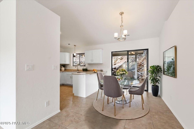 dining space featuring light tile patterned floors, baseboards, and a chandelier