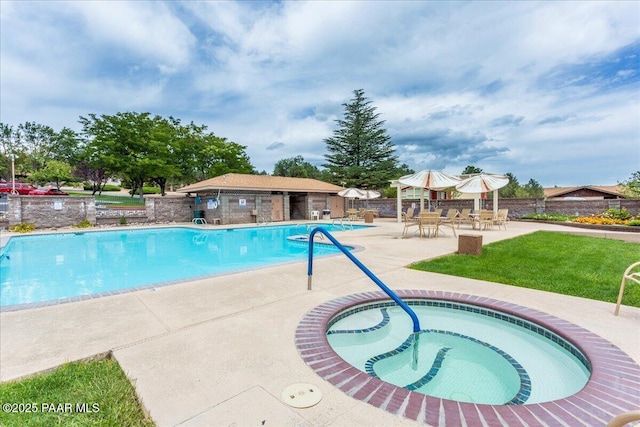 pool featuring a community hot tub, a patio, and fence