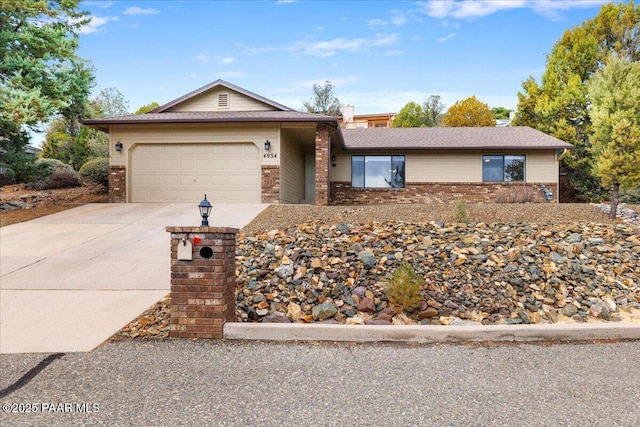 single story home featuring brick siding, driveway, and a garage