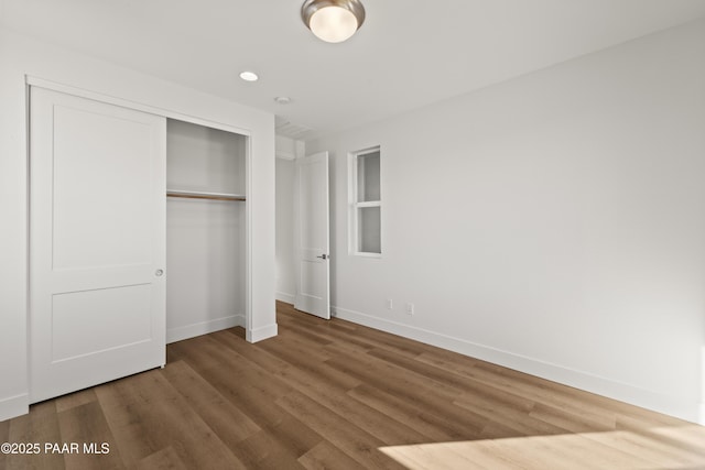 unfurnished bedroom with hardwood / wood-style floors and a closet